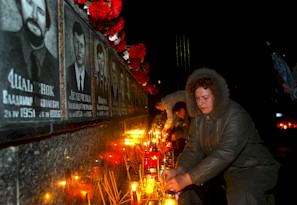 SLAVUTICH, UKRAINA: O vaduva al carei sot a murit in urma evenimentului d ela Vernobil, aseaza o candela pe piatra de mormant a pompierilor, la memorialul victimelor cernobilului in orasul Slavutich, 26 aprilie 2006. Tragedia de la Cernobil – cauzata de explozia unui reactor nuclear la 26 aprilie 1985 - a ucis intre 15.000 si 30.00 de oameni iar sase milioane continua sa traiasca in zonele contaminate. 