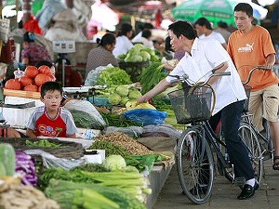 Cumparatorii aleg produse intr-o piata in aer liber. (Teh Eng Koon / AFP / Getty Images)