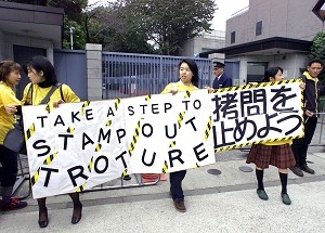 Membri japonezi ai organizatiei Amnesty International afiseaza la intrarea ambasadei chineze din Tokyo un banner in semn de protest impotriva folosirii torturii. 