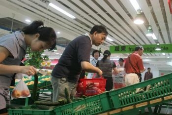 Cetatenii chinezi cumpara legume la un supermarket din Beijing, 12 iunie 2008. 