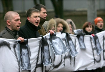 Manifestanti tinand in maini fotografia activistului din opozitia din Belarus, Alexander Borozenko, in fata tribunalului din Minsk, 8 decembrie 2008. 