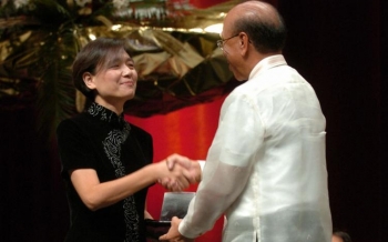 Presedintele premiilor Ramon Magsaysay, Juan Santos(D), o felicita pe Jiang Rui(S), fiica lui Jiang Yanyong, din China, castigatorul premiului pentru Servicii Publice in 2004, caruia regimul chinez nu i-a permis sa iasa din tara. 