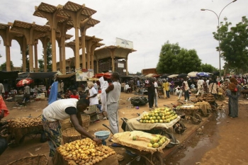 Un barbat isi aranjeaza produsele intr-o piata in Niamey, Niger. 