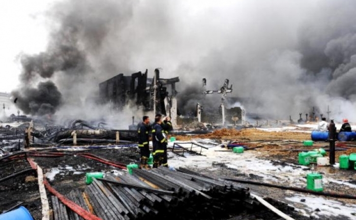 Pompieri stingand un incendiu dupa o lupta cu focul care a durat 15 ore in portul Dalian, nord-estul Chinei, 17 iulie 2010 