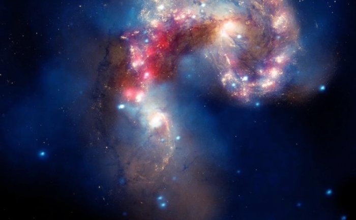 Imagine publicata de NASA, care infatiseaza galaxiile Antennae. In imagine apar date (spectrul razelor X) primite de la observatorul Chandra (reprezentate cu albastru), date primite de Hubble, in spectrul vizibil (auriu si maro), si de la Spitzer in infrarosu (rosu). (X-ray: NASA/CXC/SAO/J.DePasquale; IR: NASA/JPL-Caltech; Optical: NASA/STScI )