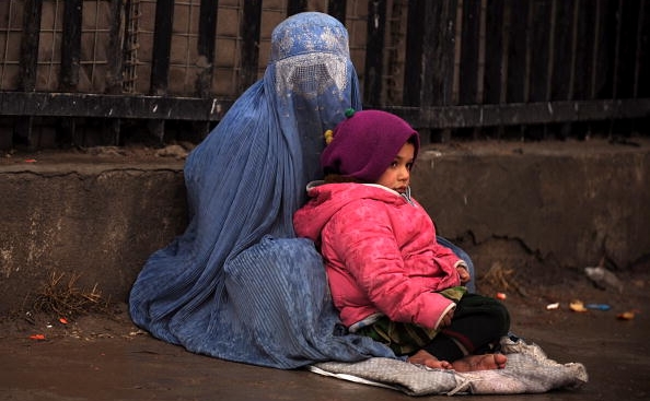 O femeie afgană şi copilul ei sunt nevoiţi să cerşească.