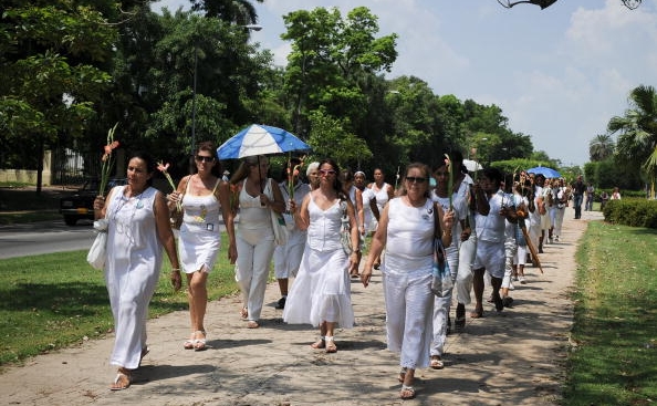 Sotii si alte rude de sex feminin ale dizidentilor cubanezi inchisi de regimul comunist, cunoscute generic sub numele de "Doamnele in alb", la o parada prin Havana, cerand eliberarea sotilor lor (ADALBERTO ROQUE / AFP / Getty Images)