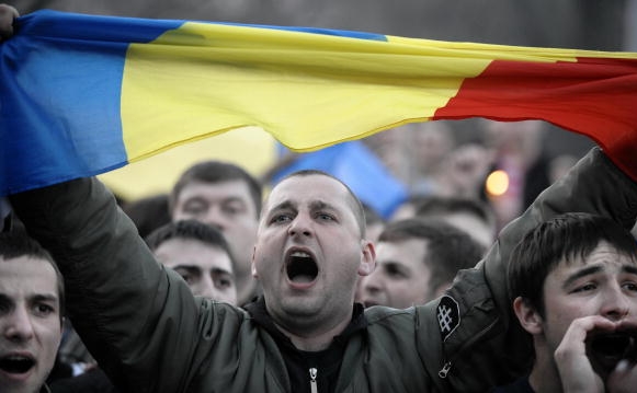 Un bărbat ţine un steag românesc în timpul unui miting la Chişinău la 06 aprilie 2009.