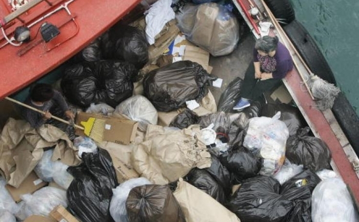 Pungi de gunoi transportate de o ambarcatiune din Hong Kong. In 2009, Hong Kong-ul a produs cea mai mare cantitate de gunoi pe cap de locuitor din lume. 
