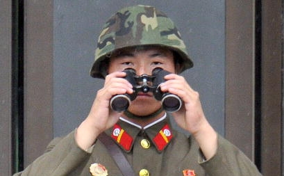 Soldat nord coreean examinand Sudul capitalist prin binoclu, in Panmunjom in Zona Demilitarizata, care separa cele doua Corei, august 2010. 