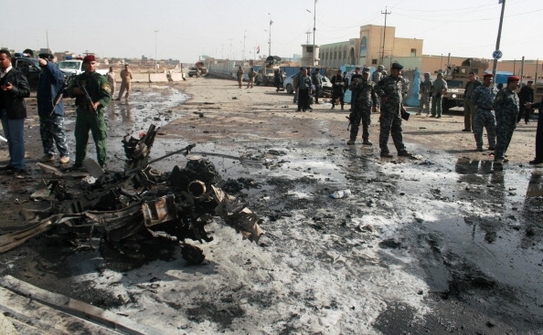 Fortele de securitate irakiene supravegheaza scena unui atac sinucigas in apropiere de birourile guvernamentale provinciale din orasul Ramadi, provincia irakiana Anbar, 12 decembrie 2010. (AZHAR SHALLAL / AFP / Getty Images)