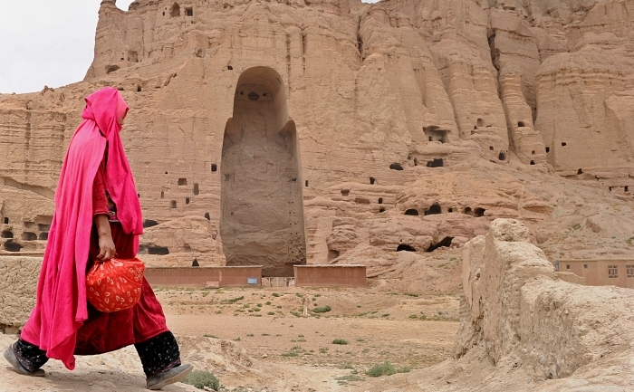 O femeie afgana trece pe langa ruinele anticei statui Budda ce fusese inaltata in piatra in orasul Bamiyan, avand o vechime de aproape 2000 de ani, dar care a fost distrusa de talibani in timpul invaziei lor din 2001.
