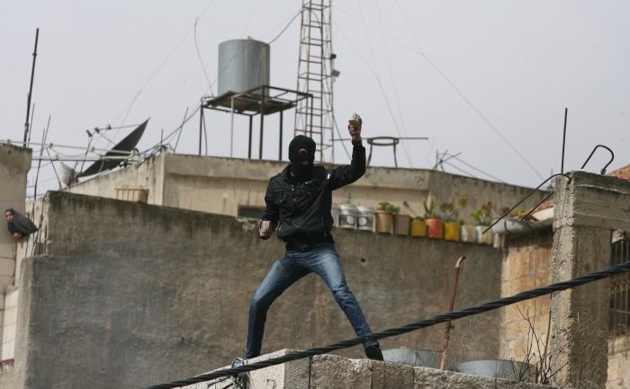 Un tânăr palestinian se pregăteşte să arunce cu o piatră împotriva forţelor israeliene în centrul oraşului Hebron din Cisiordania