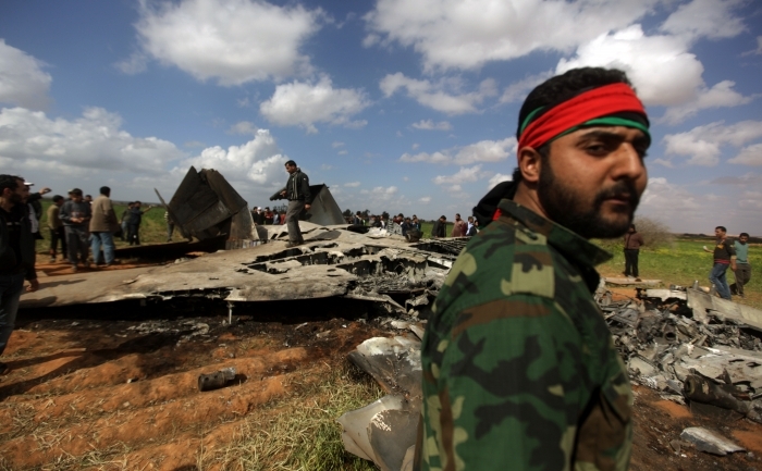 Libienii s-au strans in jurul epavei unui avion de vânătoare F-15  american in Ghot Sultan, la Sud-Est de Benghazi, 22 martie 2011, dupa prabusirea acestuia in timpul unei misiuni impotriva apararii aeriene a lui Gaddafi.
