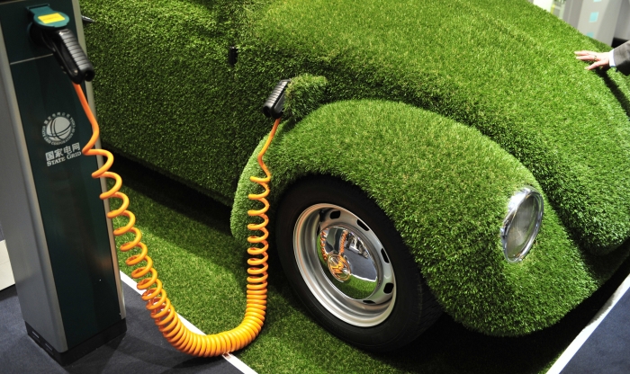 Un Volkswagen Beetle acoperit cu "iarba artificiala" isi face plinul cu "electricitate" la targul International Hannover Messe 2011, Germania