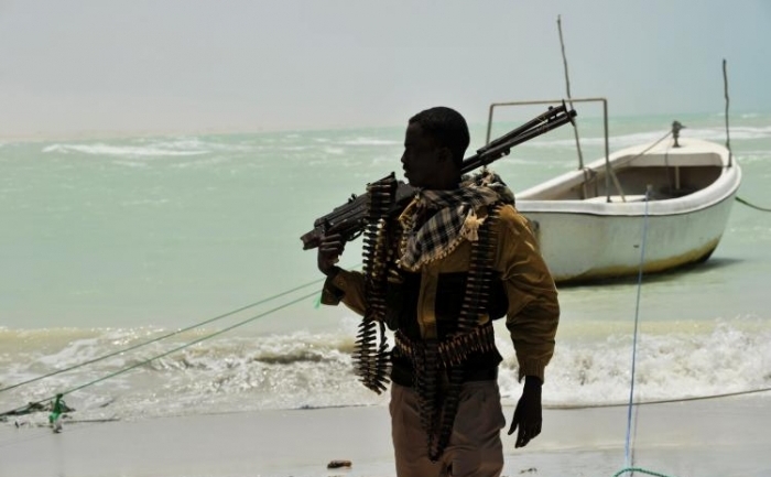 Pirat somalez cu o armă de calibru mare pe o plajă, în oraşul somalez central Hobyo.