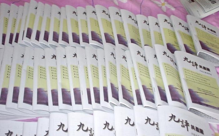Zeci de copii din "Nouă Comentarii despre Partidul Comunist", produs de un site de materiale în Shijiazhuang, China, sunt aranjate pe un pat. Acestea vor fi puse în cutiile poştale, în miez de noapte de practicanţii Falun Gong.