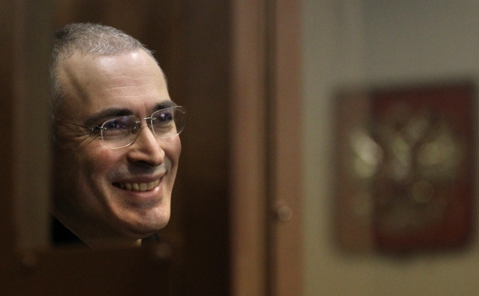 Fostul patron al Iukos, Mihail Hodorkovski, zâmbind de după panoul de sticlă caracteristic apariţiilor sale în tribunalele controlate de Putin. - ARHIVĂ