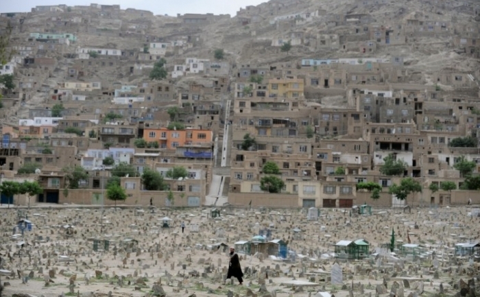 Un barbat afgan merge printr-un cimitir in partea veche a Kabulului pe 25 mai 2011