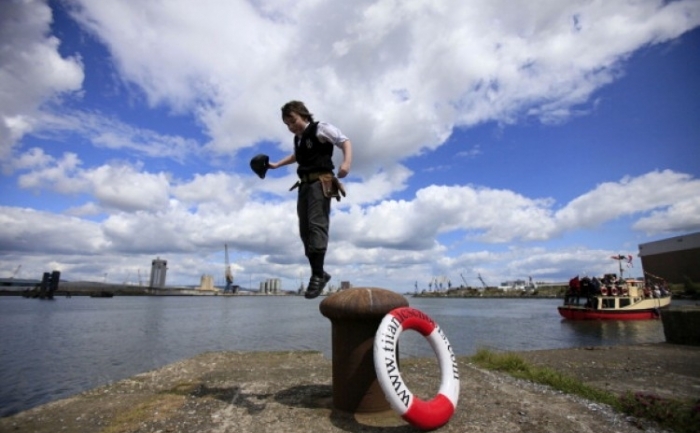 Carl Grant, 11, de la Belfast, sare de pe un ţăruş de andocare in timp ce oamenii se aduna pentru a participa la o ceremonie pentru a marca aniversarea a 100 de ani de la lansarea navei, "Titanic", în Belfast, Irlanda de Nord, la 31 mai 2011