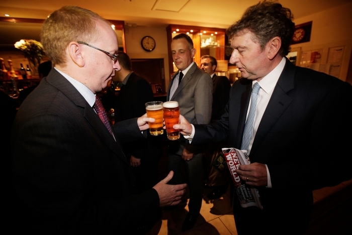 Editorul News of The World, Colin Myler (dreapta), ciocneste un pahar de bere cu unul din angajatii ziarului.