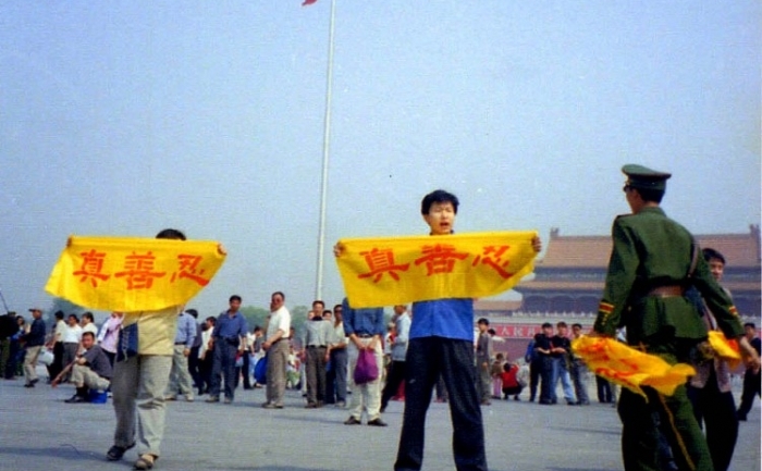 INCHEIEREA PERSECUŢIEI: practicanţii Falun Gong ţin banere in Piata Tiananmen din Beijing pe 2 mai 2001