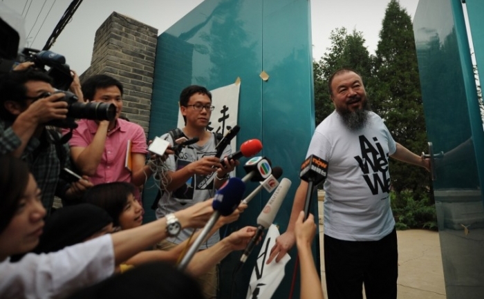 Artistul chinez Ai Weiwei vine să vorbească cu reporterii în fata studioului său din Beijing pe 23 iunie. Weiwei a acceptat sa predea la Universitatea din Berlin, dar nu este clar dacă ii va fi permisa plecarea din China.