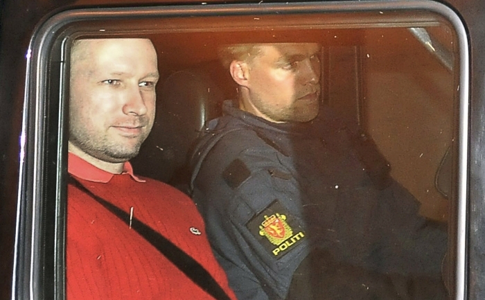 Anders Behring Breivik (in rosu) parasind tribunalul intr-o masina a politiei in Oslo, la 25 iulie 2011. (Jon-Are Berg-Jacobsen / AFP / Getty Images)