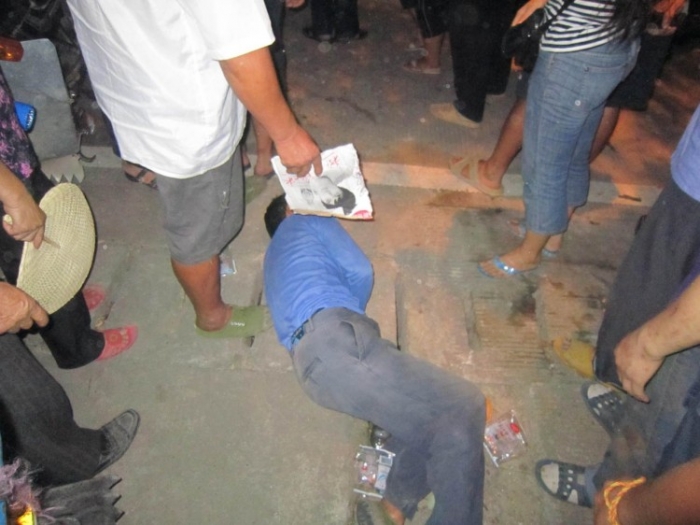 Un alt bărbat este bătut la pamant de poliţie după o revoltă în Beishan, China pe 4 august