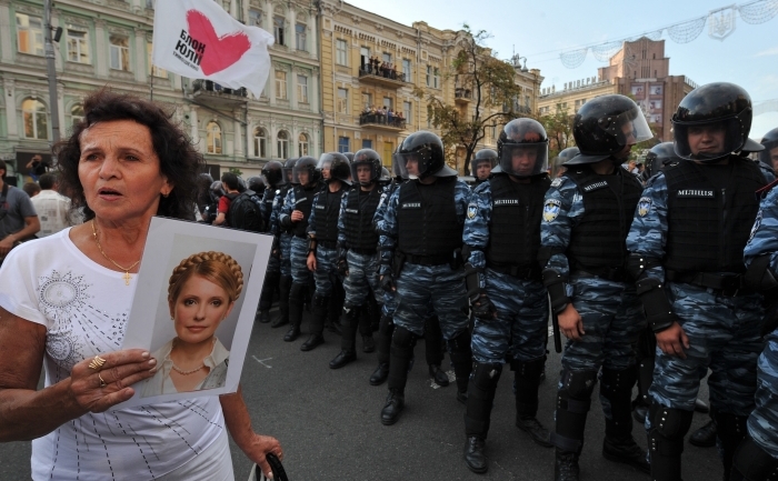 O femeie tine in mana portretul Iuliei Timoşenko in apropierea tribunalului Perciorski, Kiev, 8 august 2011. Susţinătorii fostului premier Iulia Timoşenko s-au strâns din nou miercuri  dimineaţă în centrul Kievului, înainte de reluarea procesului acesteia.
