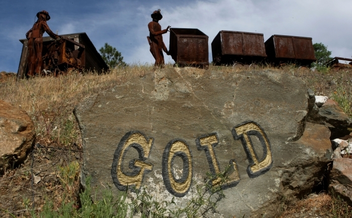 Figurine reprezentand mineri si vagoane vechi pentru minereu langa "Sutter Gold Mine" din Sutter Creek, California.