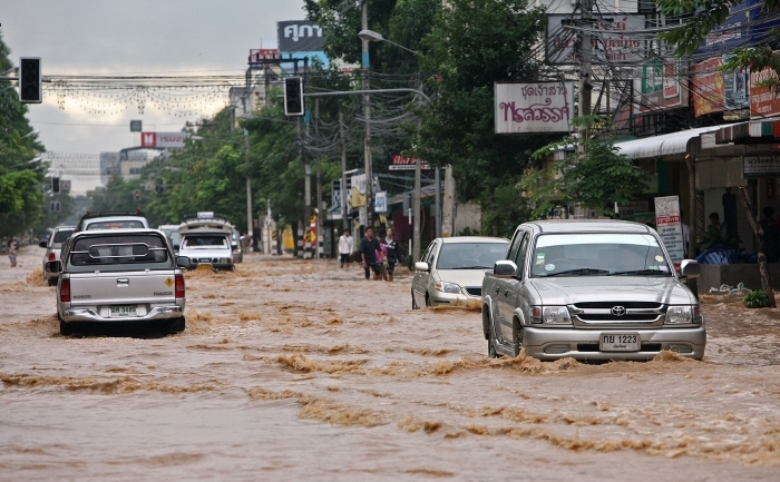 Masinile se deplaseaza pe strazile inundate din orasul nordic tailandez Chiang Mai in 29 septembrie 2011.