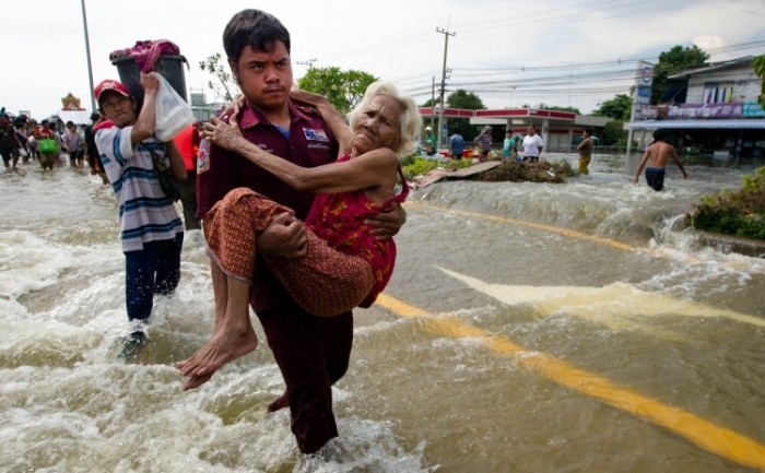 O femeie in varsta este evacuata in timp ce inundatiile lovesc orasul tailandez Ayutthaya.