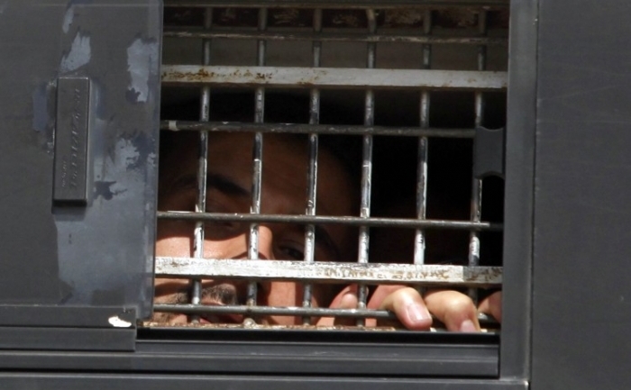 Un prizonier palestinian se uita dintr-un autobuz al Serviciului Israelian al Penitenciarelor in timp ce paraseste închisoarea Nafha, din Mitzpe Ramon, Israel pe 16 octombrie 2011 (Lior Mizrahi / Getty Images)