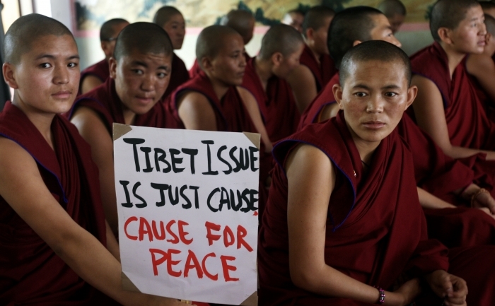 Calugarite tibetane in exil afiseaza un banner pe care scrie "Problema  tibetana este doar o cauza pentru pace", in Centrul Tibetan pentru  Asistenta din Kathmandu. Joi, 3 noiembrie 2011, o calugarita a murit  dupa ce si-a dat foc in provincia chineza Sichuan in semn de protest fata de politica regimului comunist chinez aplicata in Tibet.