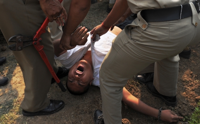 Un manifestant, identificat ca Sherab Tsedor, fost membru executiv al  Congresului Tibetan pentru Tineret din Delhi, striga in timp ce este  tarat de politistii indieni la cateva clipe dupa ce a incercat sa isi  dea foc in fata ambasadei chineze din New Delhi in 4 noiembrie 2011. (ROBERTO SCHMIDT / AFP / Getty Images)
