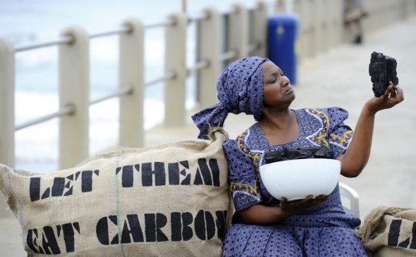 
Un activist Oxfam pretinde că mănâncă o bucată de cărbune ca protest îndreptat împotriva Convenţiei ONU privind schimbările climatice,  pe 9 decembrie 2011 în Durban.
