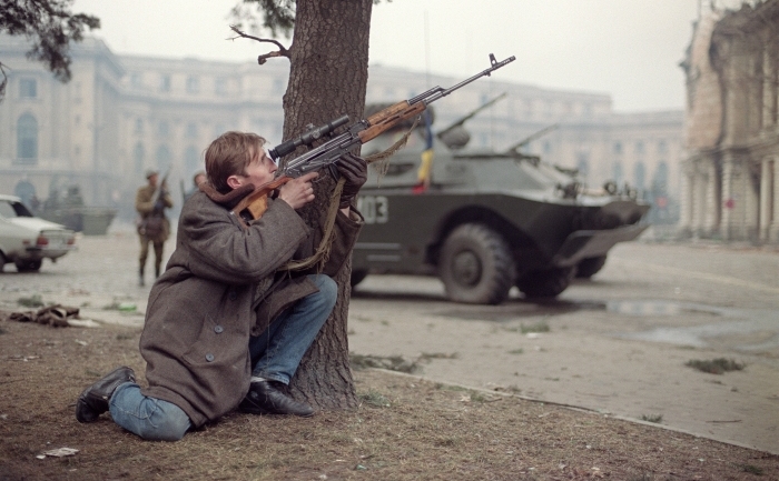 Un barbat in civil trage cu arma in centrul Bucurestiului, 24 decembrie 1989. (JOEL ROBINE / AFP / Getty Images)