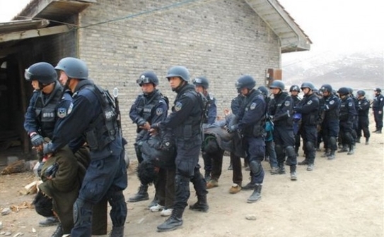 Tibetanii sunt forţaţi să se aplece în faţă în timp ce sunt luaţi de fortele de securitate chineze. (Forum militar chinez)