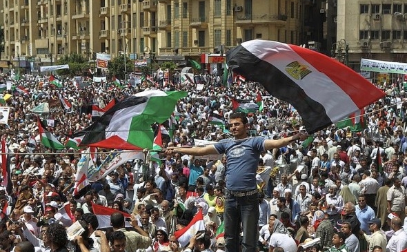 Un militant egiptean fluturând steaguri egiptene şi palestiniene în Piaţa Tahrir, 13 mai 2o12
