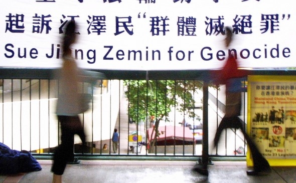Un banner în sprijinul proceselor intentate la Bruxelles împotriva dictatorului Jiang Zemin învinuit de genocid, 30 august 2003 în Hong Kong (Laurent Fievet / AFP / Getty Images)