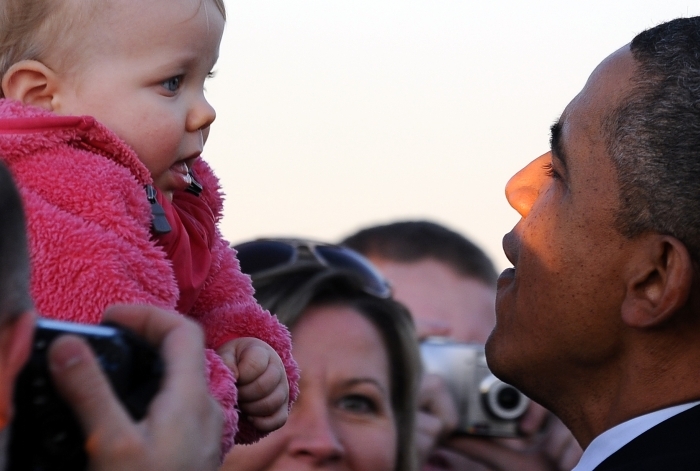 Preşedintele american, Barack Obama, admiră un copil şi salută oamenii la aeroportul O'Hare din Chicago, 11 ianuarie, la sosirea sa pentru participarea la evenimentele de campanie.