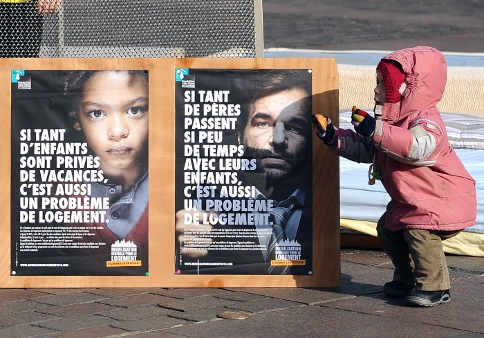 Un copil stă lângă o pancartă în timpul unei demonstraţii dedicată lipsei spaţiilor pentru locuinţe şi a adăposturilor, 12 ianuarie, Toulouse, sudul Franţei.