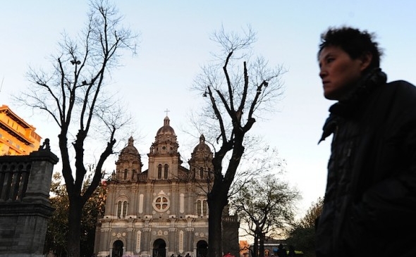 Un trecător pe lângă catedrala Sf. Iosif, din Beijing. Catedrala aparţine Bisericii Patriotice Chineze, o variantă la Biserica Romano-Catolică, născocită de Partidul Comunist Chinez, care interzice referiri la Vatican şi Papă (Frederic J. Brown / AFP / Getty Images)
