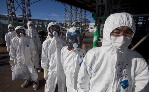 Muncitori în salopete îşi aşteaptă intrarea în reactorul nuclear Fukushima Daiichi, 12 noiembrie 2012