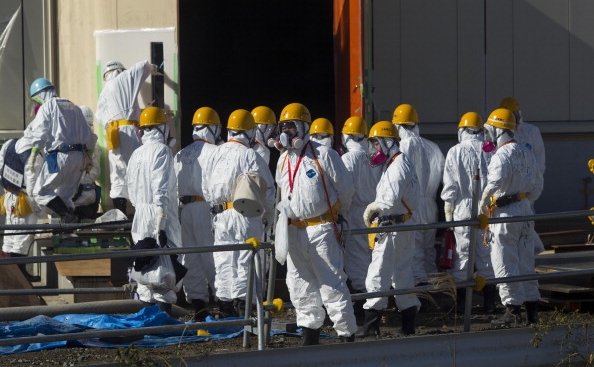 Muncitori în salopete îşi aşteaptă intrarea în reactorul nuclear Fukushima.