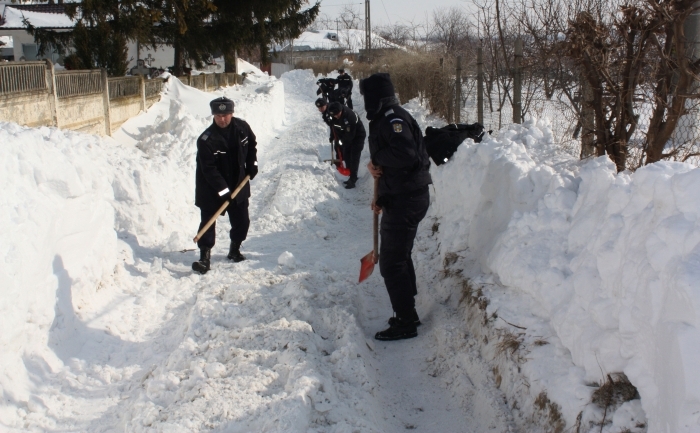 Jandarmii ajută la deszăpezirea unui drum în una din localităţile grav afectate de intemperii. (www.gov.ro)