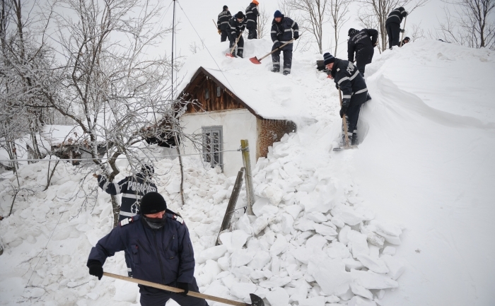 Pompierii dau zăpada care acoperă o casă din localitatea Cârligu Mic, jud Buzău, 11 febr 2012. Mai multe localităţi din România sunt izolate din cauza căderilor masive de zăpadă din ultima perioadă. (DANIEL MIHAILESCU / AFP / Getty Images)