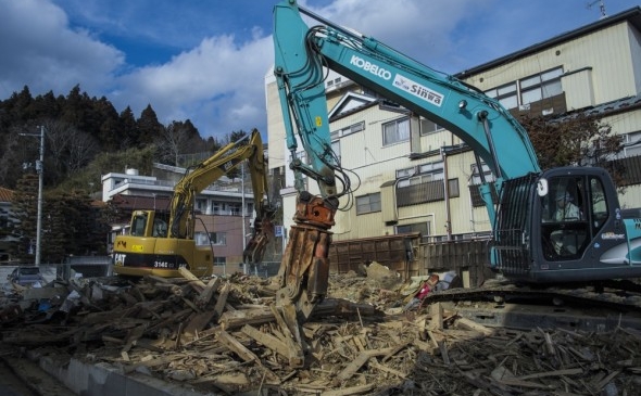 Un angajat al Primariei elimină resturile unei case distrusă de tsunami  pe 7 martie 2012 în Kesennuma, Japonia