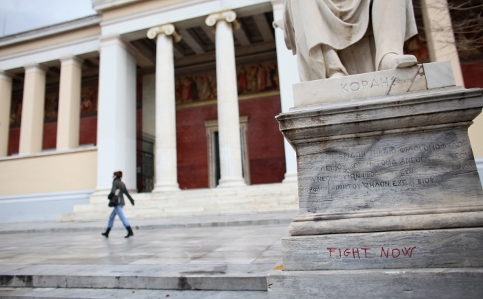 Graffiti pe o statuie din faţa Universităţii din Atena. (Oli Scarff / Getty Images)